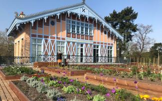 Vegetable and herb plots in front of a historic building